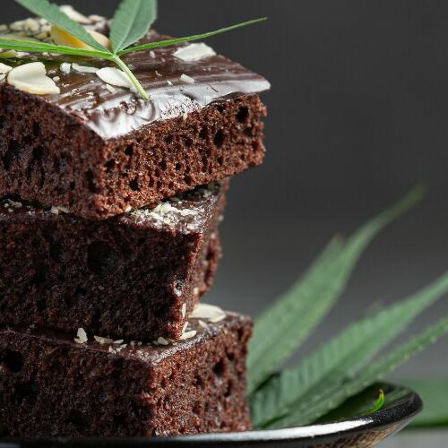 Three stacked cannabis-infused brownies topped with a cannabis leaf