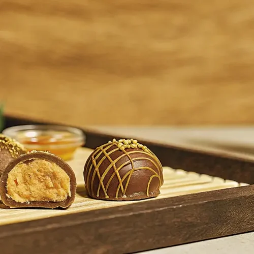 Close-up of cannabis chocolate truffles with rich peanut butter filling on a wooden tray