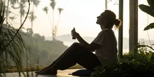 Person in a calm setting using cannabis oil for anxiety, symbolizing natural stress relief.