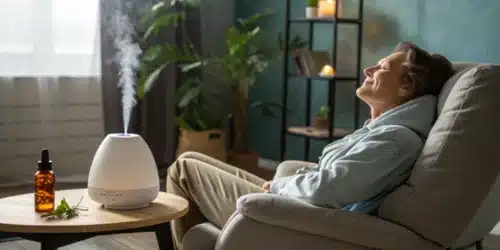 Relaxed woman enjoying aromatherapy with a diffuser, seated in a cozy room with a CBD dropper bottle on a nearby table