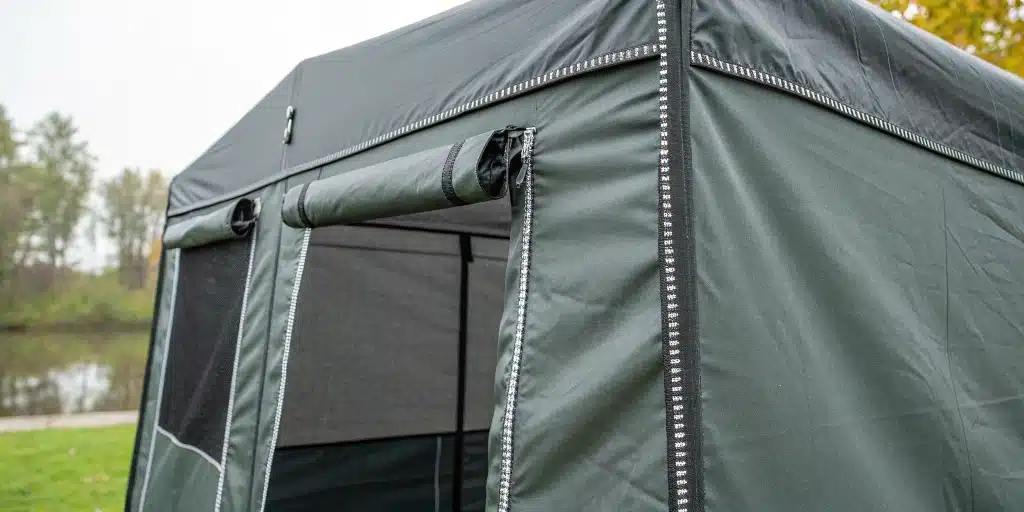 Weather-resistant fabric of outdoor grow tents with reinforced seams and secure zippers.